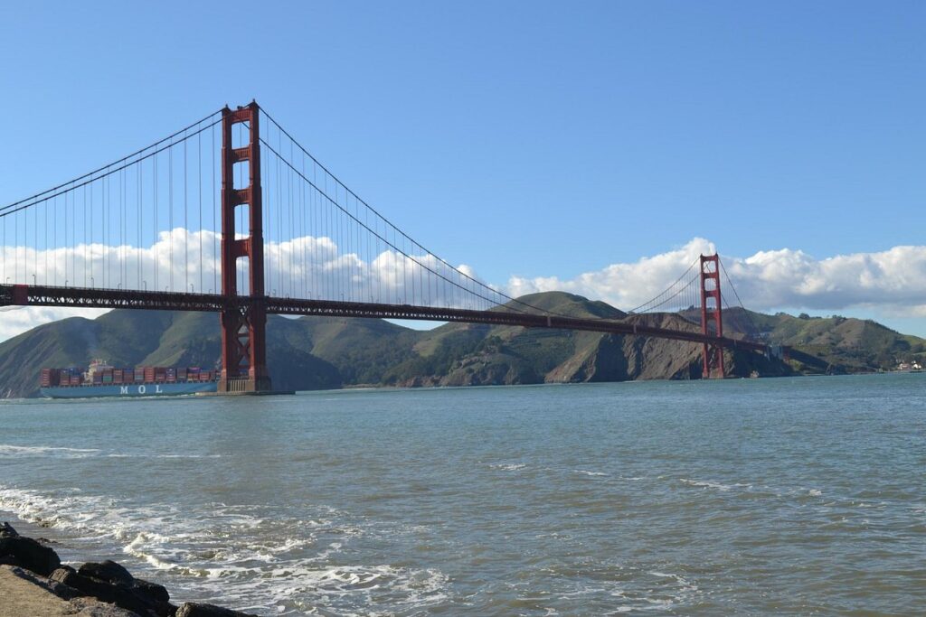 Golden Gate Bridge in the distance with calm waters at Crissy Field.