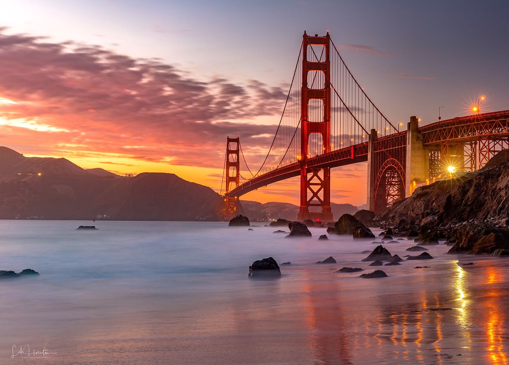 Golden Gate glowing at sunset as seen from Marshallâs Beach.