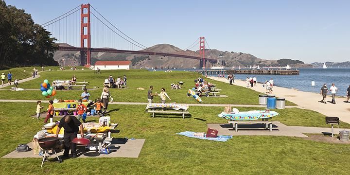 People enjoying a sunny picnic with a view of the Golden Gate Bridge during Labor Day Weekend San Francisco 2025