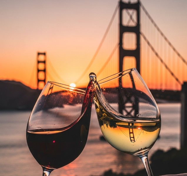 Wine glasses clinking in front of the Golden Gate Bridge at sunset