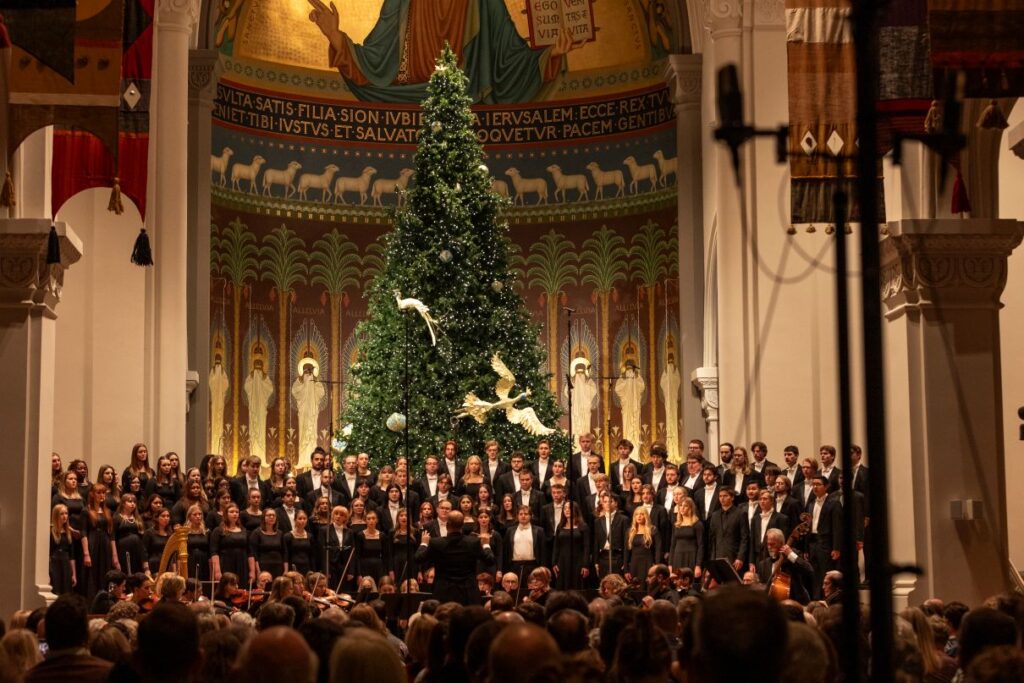 A choral group performing in a decorated church or auditorium.