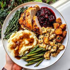 Gourmet Thanksgiving plate with turkey, cranberries, and herbs.