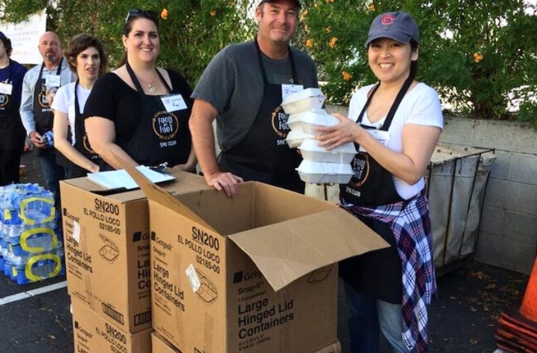 Volunteers collecting and sorting food donations at a Thanksgiving charity event in San Francisco.